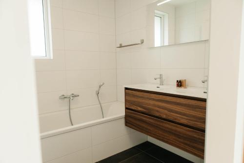 un bagno con vasca, lavandino e specchio di Watervilla buitenzijde | 6 personen a Heeg