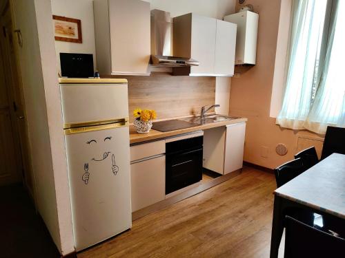 une petite cuisine avec un réfrigérateur et un évier dans l'établissement Casa di Osio - Porta Romana, à Sienne