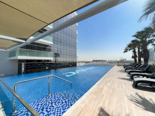 ein Swimmingpool an der Seite eines Gebäudes in der Unterkunft StayShort - Spacious Carson C Studio in Damac Hills in Dubai Marina