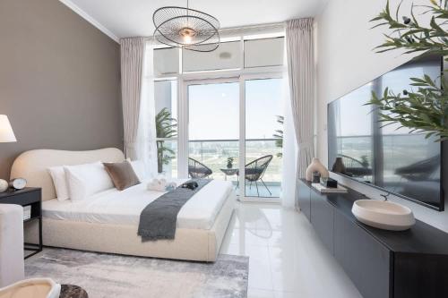 ein Schlafzimmer mit einem Bett und einem großen Fenster in der Unterkunft StayShort - Spacious Carson C Studio in Damac Hills in Dubai Marina