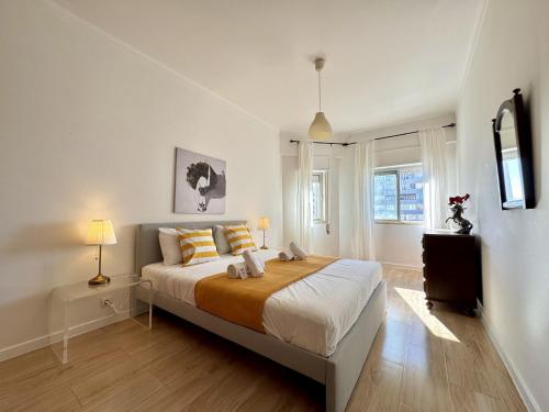 una camera da letto con un letto grande e una finestra di Quarteira Central 3 by Homing a Cavacos