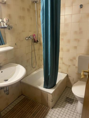 a bathroom with a tub and a sink and a toilet at LIVI Hostel und Pension in Dortmund