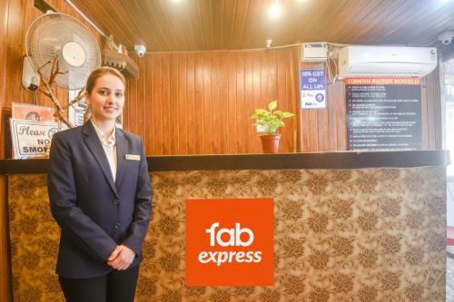 a woman in a suit standing next to a flag express sign at Via Corinthia Boutique Rooms - Nr Candolim Beach in Candolim