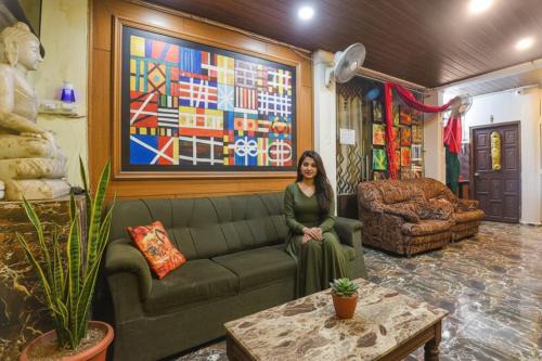 a woman sitting on a couch in a living room at Via Corinthia Boutique Rooms - Nr Candolim Beach in Candolim