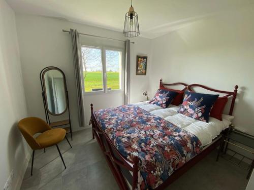 a bedroom with a bed and a mirror and a chair at Le gîte d'Elia in Montech
