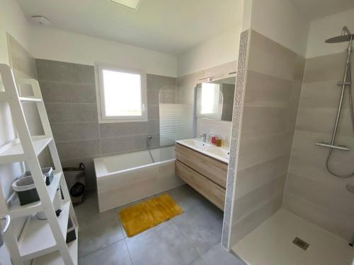 a bathroom with a tub and a sink and a shower at Le gîte d'Elia in Montech