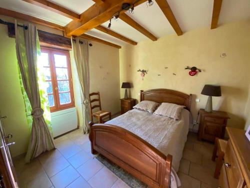une chambre avec un lit en bois et une fenêtre dans l'établissement La maison des lieux, à Fauroux