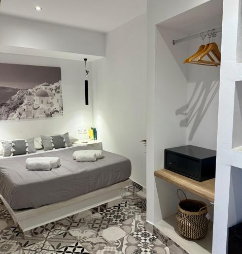 1 dormitorio con 1 cama grande y paredes blancas en Fira Basement Studios, en Santorini