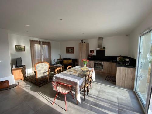 un salon avec une table et une cuisine dans l'établissement Le Pigeonnier - TG2260, à Nègrepelisse