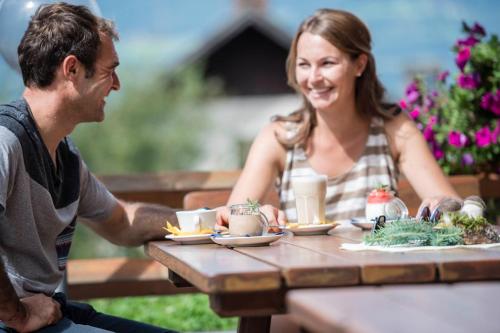 Un hombre y una mujer sentados en una mesa en MyLiving - Hotel B&B, en San Lorenzo di Sebato
