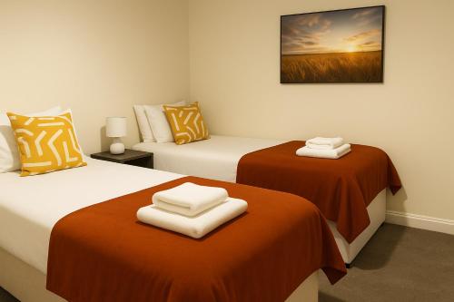 QueensferryBright 3BR Home 6 Guests ideal for Contractors的两张带橙色和白色床单的床