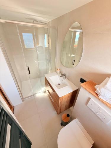 a bathroom with a sink and a toilet and a mirror at Chalet école des cimes in Bozel