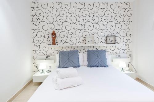 een slaapkamer met een wit bed en zwart-wit behang bij Gatova Sunset Retreat in Gátova