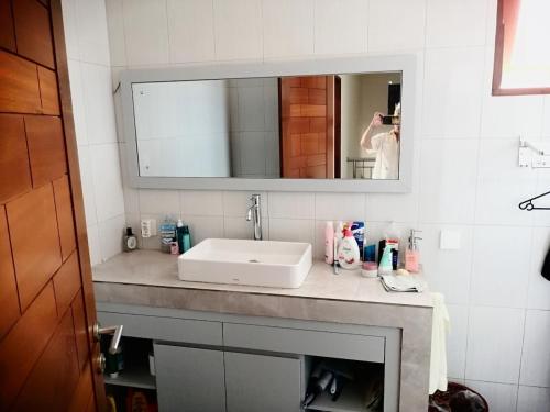 Un baño con un lavabo blanco y un espejo. en Pondok Pradhipta, en Dalung