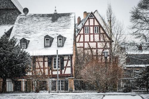 an old house with a snow covered roof at Fewo Geib in Meisenheim