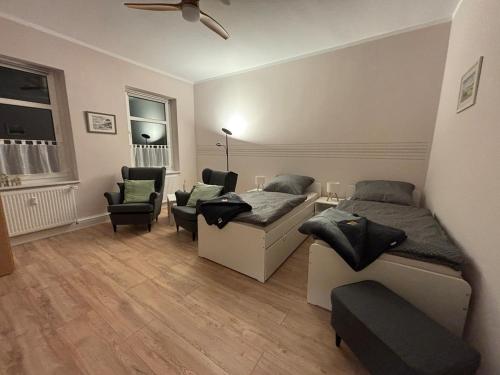 a bedroom with two beds and chairs in a room at FeWo JW Altentreptow in Altentreptow