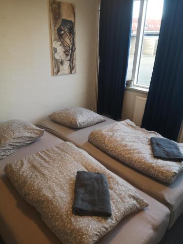 three beds in a room with blankets on them at 2 værelser m minikøkken brusekabine og toilet 4 prs in Kolding