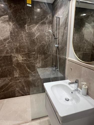 a bathroom with a sink and a shower at Balcony studio in Sheikh Zayed