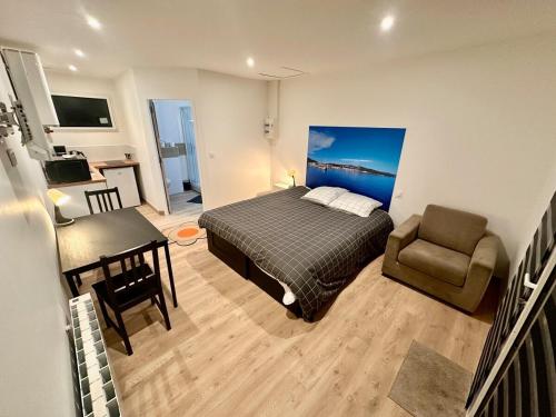 une chambre avec un lit, une chaise et un bureau dans l'établissement Refuge des voyageurs Studio neuf - Horizon indépendant rez de jardin, à Plouédern