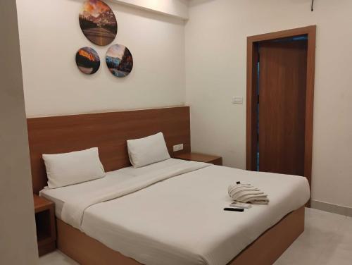 a bedroom with a bed with two plates on the wall at Hotel O Mirage Suites in Bengaluru
