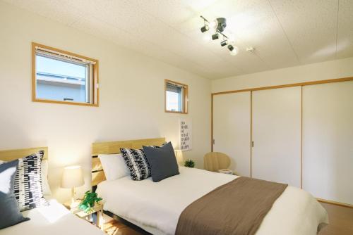 a bedroom with a large bed and a window at 阿蘇ビューテラス in Aso