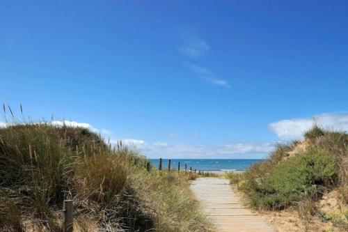 einen Weg zum Strand mit dem Ozean im Hintergrund in der Unterkunft Camping 4 étoiles - Piscine - cbgcb0b in Saint-Jean-de-Monts