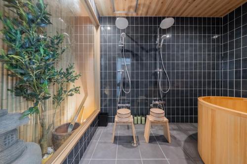 two stools in a bathroom with a shower at 蝶 プレイルーム家族で楽しめるお部屋 手作りの和風のお部屋で疲れを癒す 11台のベッド 22名利用 in Osaka