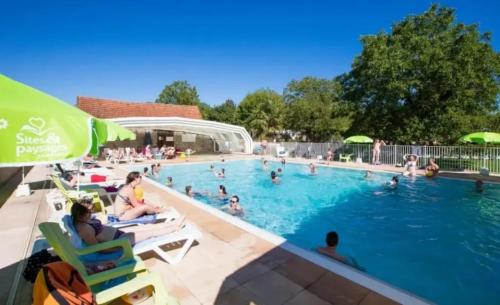 een zwembad met mensen in het water bij Camping 4 étoiles - Piscine - eed0fi in Thégra