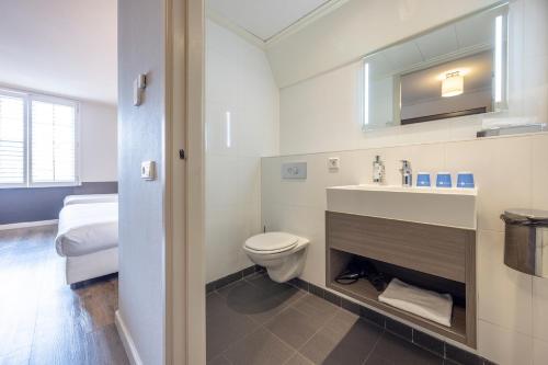 une salle de bains avec toilettes et lavabo dans l'établissement Fletcher Hotel - Restaurant Nautisch Kwartier, à Huizen