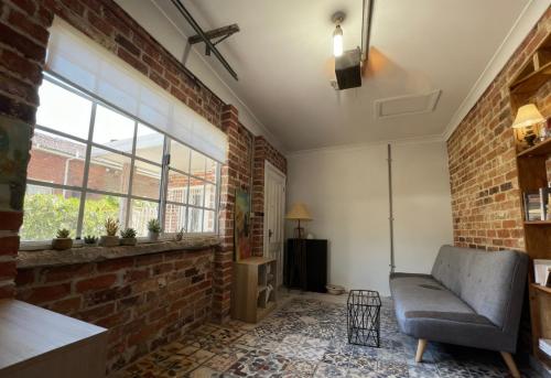 a living room with a brick wall and a couch at Burwood Family Guest Home in Sydney