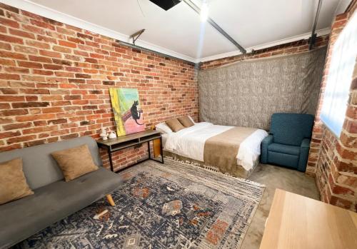 a bedroom with a bed and a brick wall at Burwood Family Guest Home in Sydney
