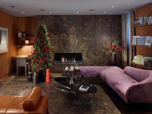 a living room with a couch and a christmas tree at The Emblem Prague Hotel - Preferred Hotels & Resorts in Prague