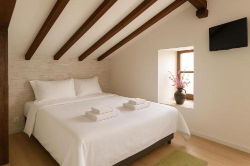 ein Schlafzimmer mit einem weißen Bett mit Handtüchern darauf in der Unterkunft Mundaka Sea Flat in Mundaka