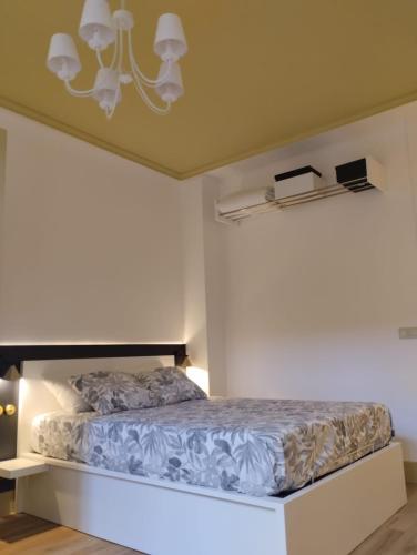 a bedroom with a bed and a chandelier at La silla de San Bernardo in Avilés