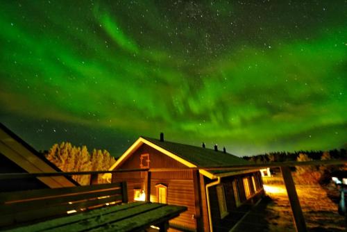 a cabin under the aurora in the sky at Riverfront Aurora Chalet in Kiruna