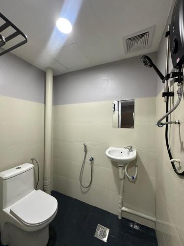 a bathroom with a toilet and a sink at Lux City Hotel in Seremban