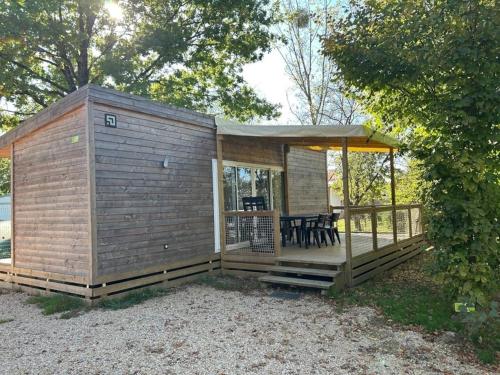 a wooden cabin with a deck with a tent at ZEcamping 4 étoiles animaux acceptés bain à remous sauna et solarium in Apremont