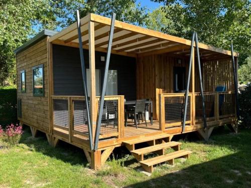 eine große Holzhütte mit Veranda und Terrasse in der Unterkunft Camping 4 étoiles - Piscine - cbgcb0b in Saint-Jean-de-Monts