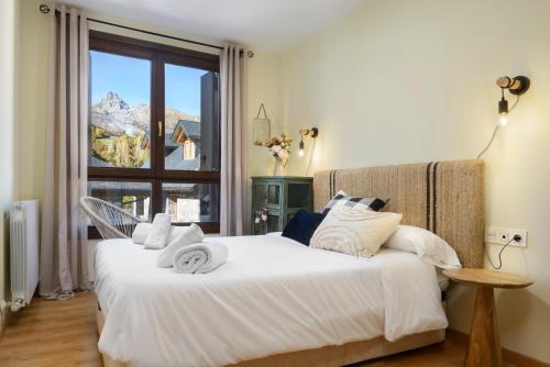 two beds in a bedroom with a view of a mountain at Apartamento Vico in Escarrilla