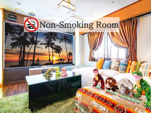 una habitación con una sala de fumadores con mural de palmeras en Hotel Balian Resort Tomei Kawasaki I.C., en Kawasaki