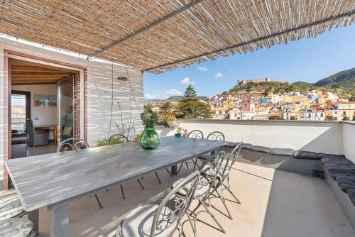 a table and chairs on a balcony with a view at Bosa Eye House 1873 in Bosa