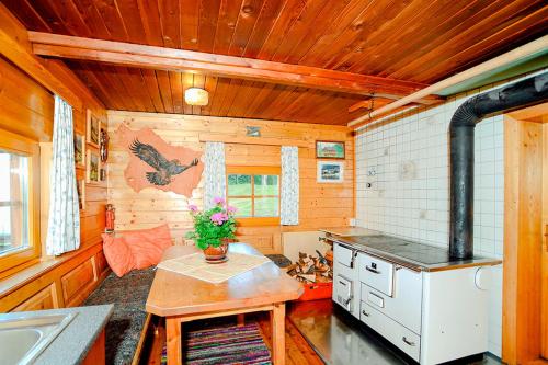 Una cocina con estufa y mesa en una cabaña. en Almhütte Haritzer, en Schachnern