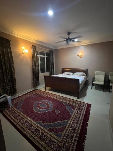 a bedroom with a bed and a rug on the floor at D'Huda Homestay in Sungai Petani