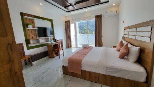 ein Schlafzimmer mit einem großen Bett und einem Fernseher in der Unterkunft Rosa Mystica Hotels & Resorts in Anachal