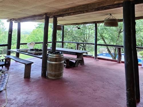 ein Raum mit einem Tisch, einer Bank und einem Fass in der Unterkunft Cerro Lajoubert Casa Quinta in Fachinal