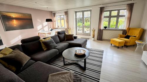 a living room with a couch and a table at Modern vacation Home - Close to sea and nature. in Hejls