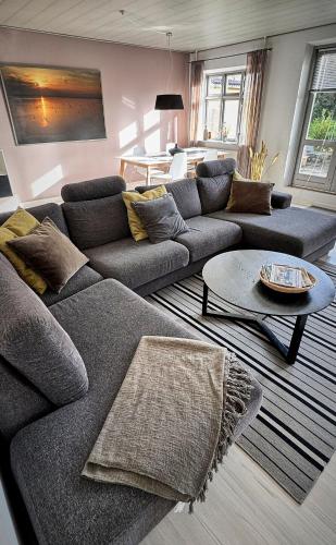 a living room with a couch and a table at Modern vacation Home - Close to sea and nature. in Hejls