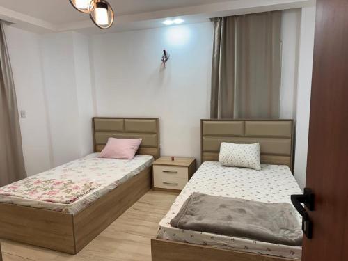 New cairoرويال شقة بالتجمع الخامس امتداد الجامعة الامريكية的有两张床和一扇窗户的卧室