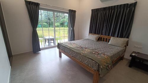 une chambre avec un lit et une grande fenêtre dans l'établissement The Royal Ascot Holiday Home with private pool, à Alibaug