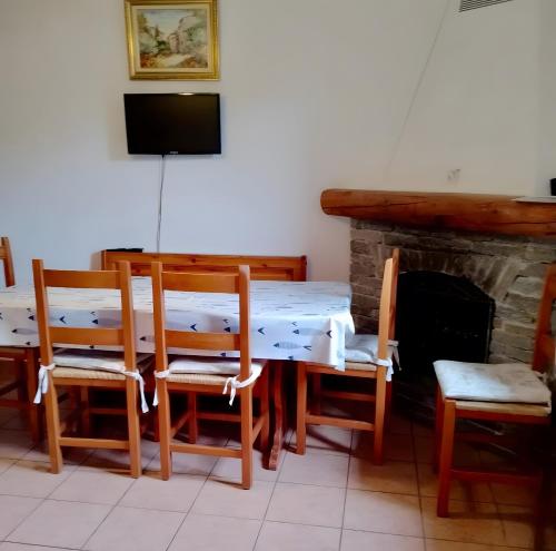 ein Esszimmer mit Tisch und Stühlen und einem Kamin in der Unterkunft Chalet Bellavista in Chiesa in Valmalenco